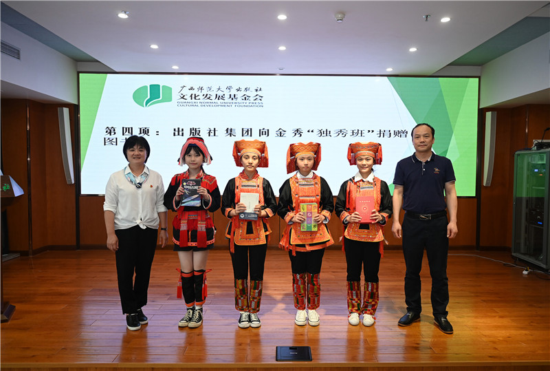 廣西師范大學(xué)出版社集團副總裁、工會(huì )主席莫曲波（右一）代表出版社向金秀“獨秀班”同學(xué)贈送圖書(shū)（李顯楊攝）.jpg